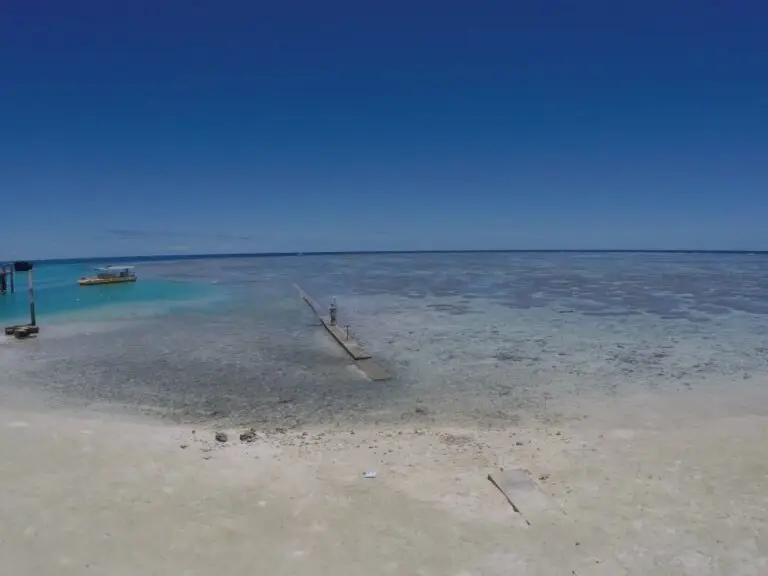 Vibrant blue waters and sandy shoreline at low tide.