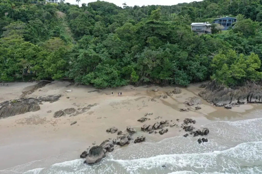 Aerial view of a secluded beach with rocks.