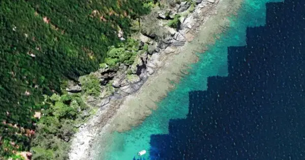 Aerial view of rugged coastline and turquoise waters.