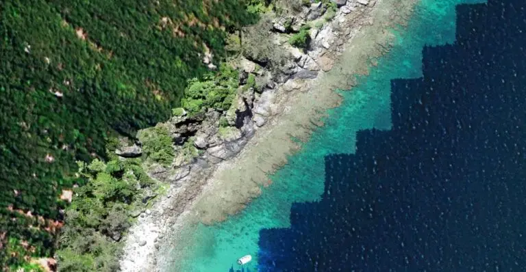 Aerial view of rugged coastline and turquoise waters.