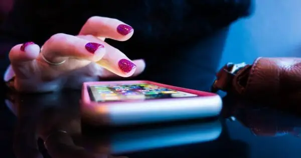 Person using a smartphone with bright nails.