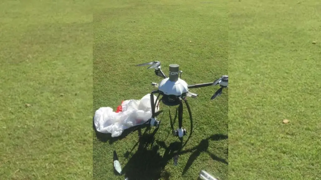 Drone on grass with debris nearby.