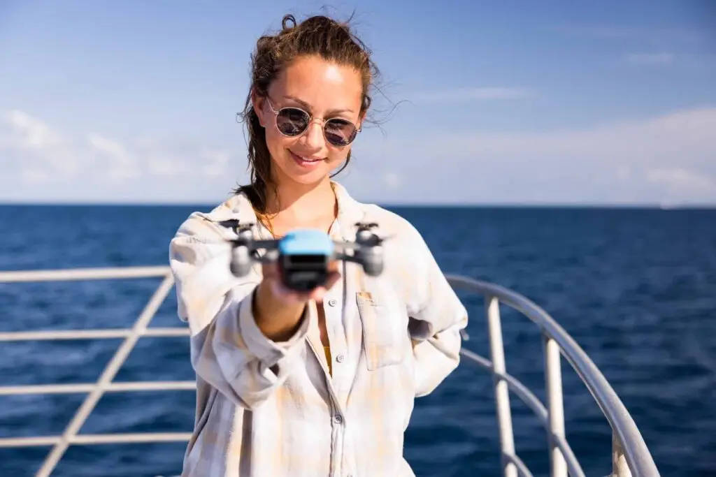 Woman holding a drone on a boat.