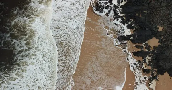 Aerial view of waves crashing on rocky coastline.