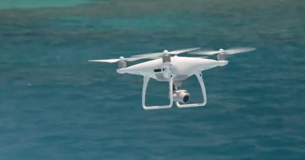 Drone flying over blue ocean waters.