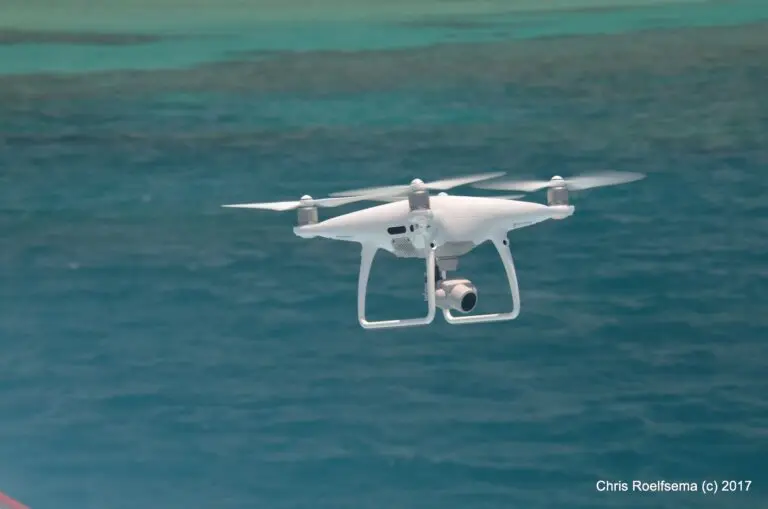 Drone flying over blue ocean waters.