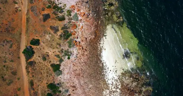 Aerial view of rocky coastline and sandy beach.