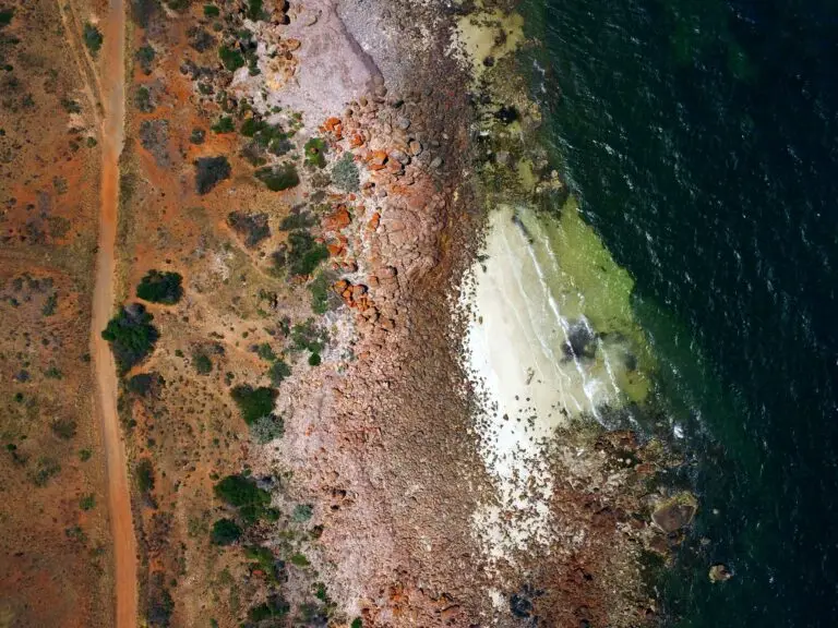 Aerial view of rocky coastline and sandy beach.