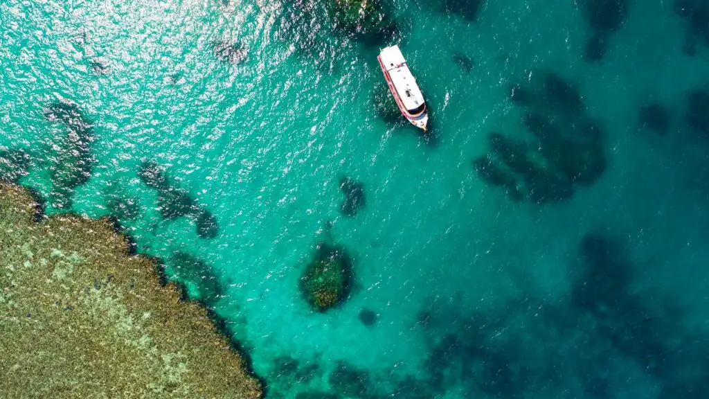 Aerial view of a boat on turquoise water.