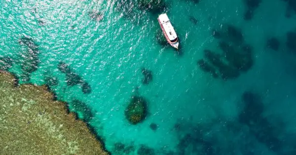 Aerial view of a boat on turquoise water.