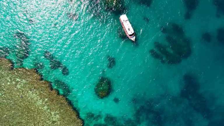Aerial view of a boat on turquoise water.