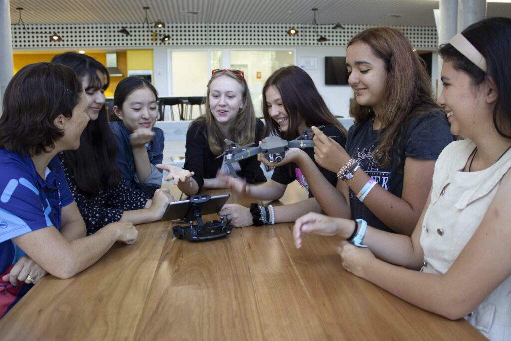 Group of girls around a table with a drone