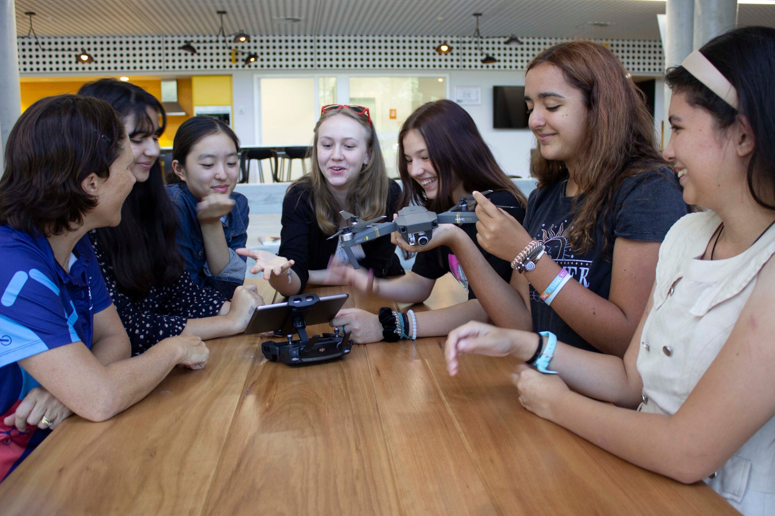 Group of girls around a table with a drone