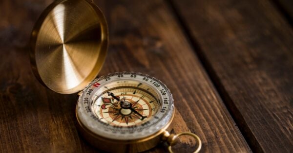 Brass compass open on wooden table