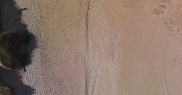 Aerial view of sandy beach with footprints