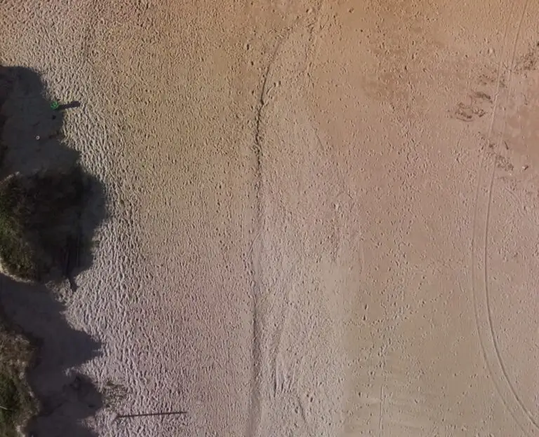 Aerial view of sandy beach with footprints