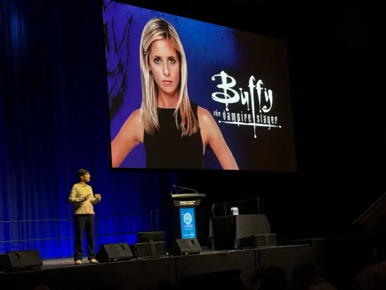 Speaker presenting with Buffy the Vampire Slayer backdrop.