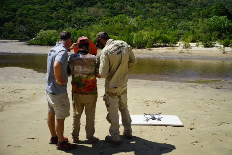 People observing drone on the beach.