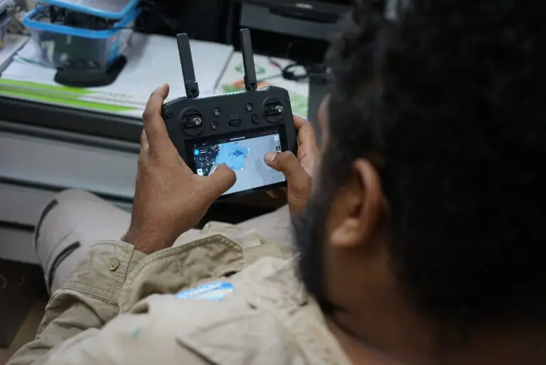 Person using a drone controller indoors.